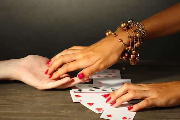 reading the lines hand and woman's hands on grey backcground