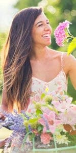woman on bike smelling flowers