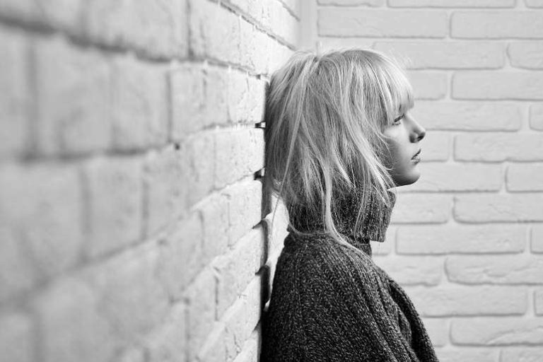 Anxious Woman leaning on a wall