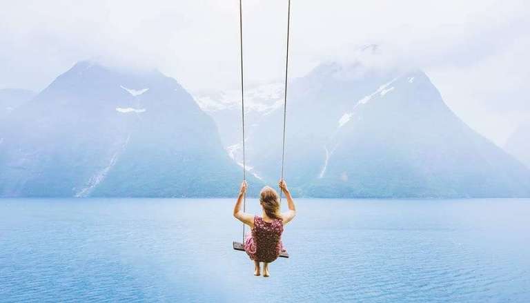 Woman on Sky Swing with Mountains in Distance
