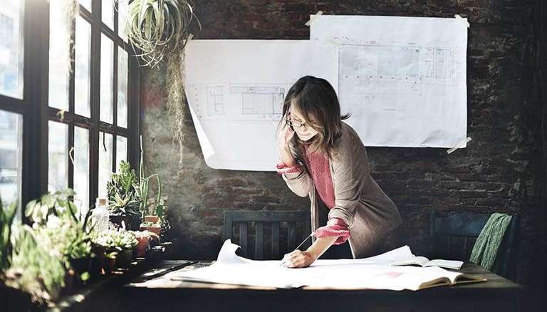 Woman drawing plans with many plants around