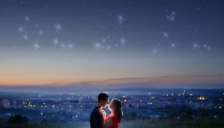 couple standing under starry sky with zodiac signs