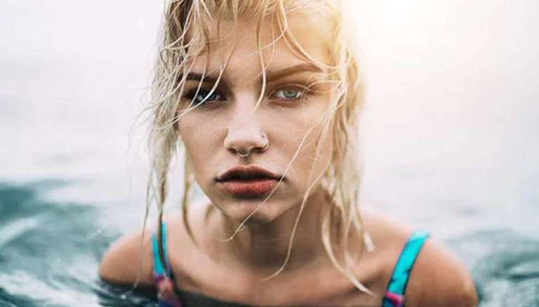 Girl with wet messy hair standing in water