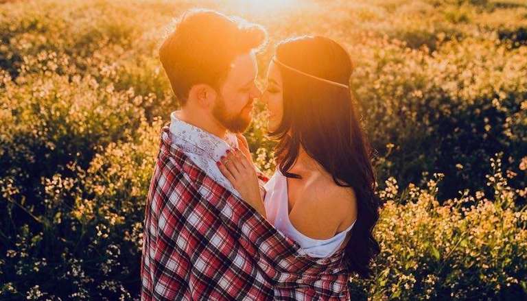 Couple Embracing Closely in Sunset Field of yellow flowers