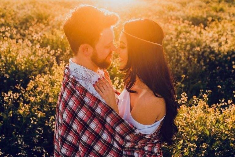 Couple Embracing Closely in Sunset Field of yellow flowers