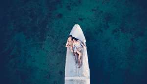 Couple on Dramatic White Boat on Blue Water